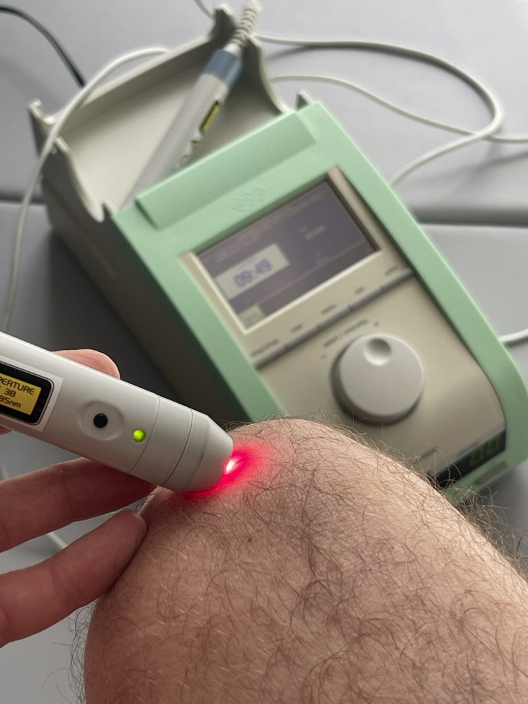Laseroterapia na kolanie, urządzenie medyczne z wyświetlaczem.